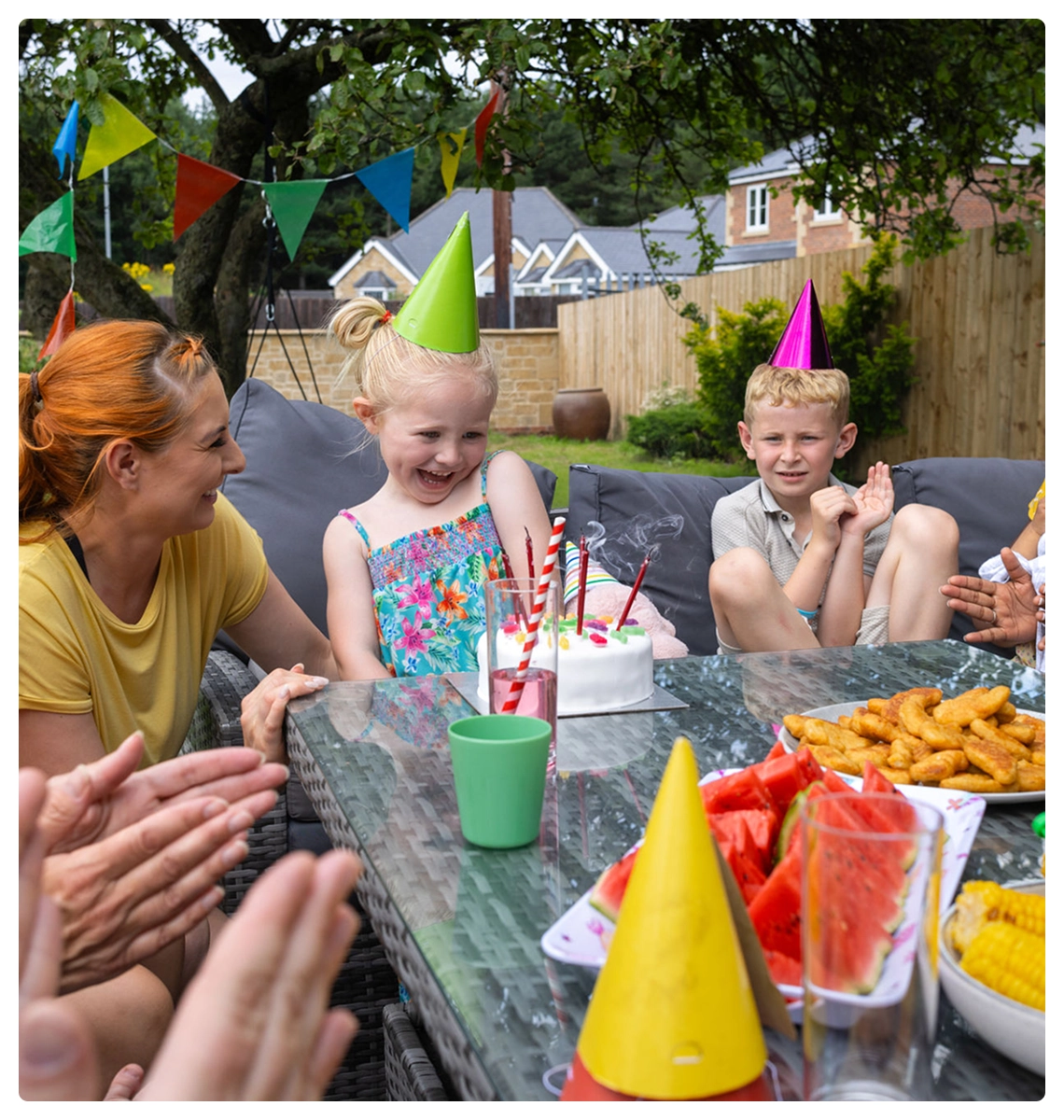 Children celebrating birthday with cake outdoors
